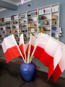 Flagi Polski w bibliotece szkolnej.