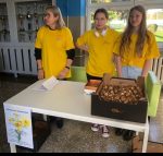 Akcja szkolnego wolontariatu: uczennice sprzedające cebulki żonkili.